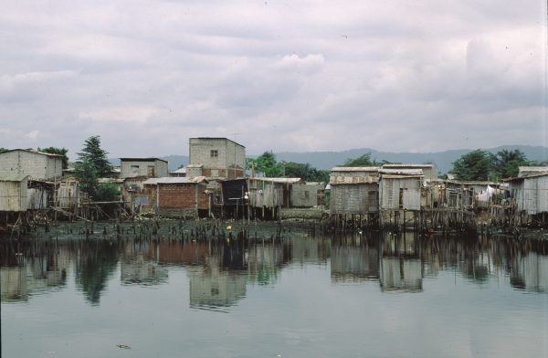 Informal settlement built along a river in Ecuador. Many structures are built on stilts over the water. Santiago de Guayaquil, Ecuador, 1999.